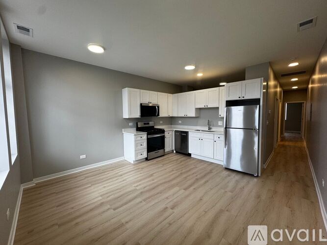 A kitchen with wooden floors and stainless steel appliances.