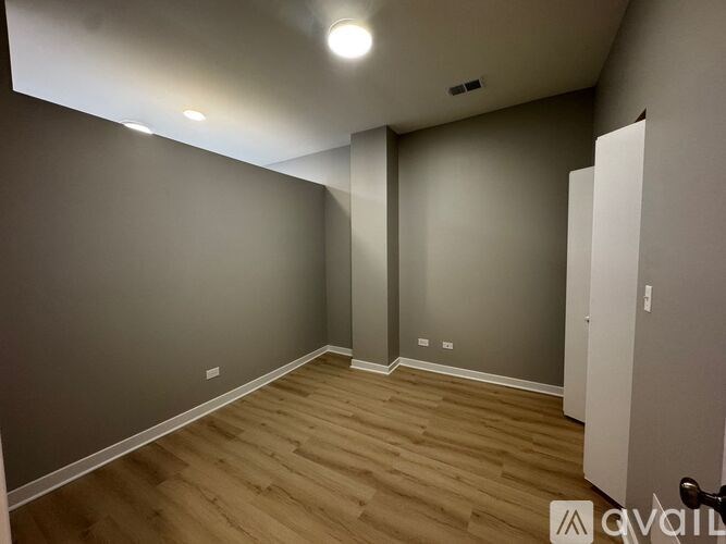 A room with wooden flooring and grey walls.