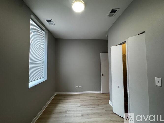 A room with a white door and a window with blinds.