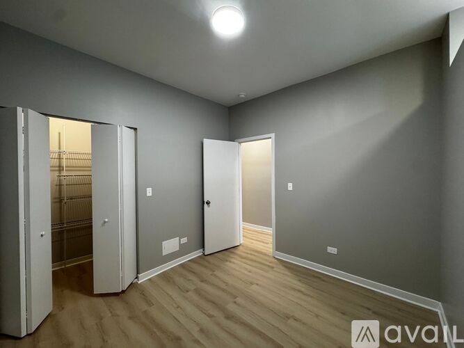 A room with wooden floors and two open doors.