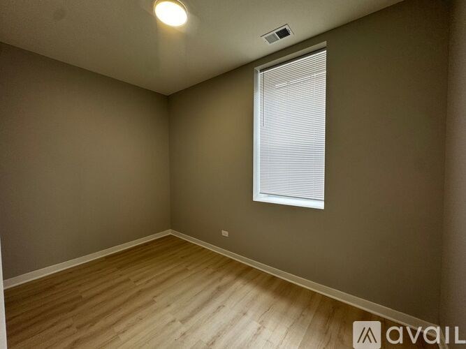 A room with a window and wooden flooring.