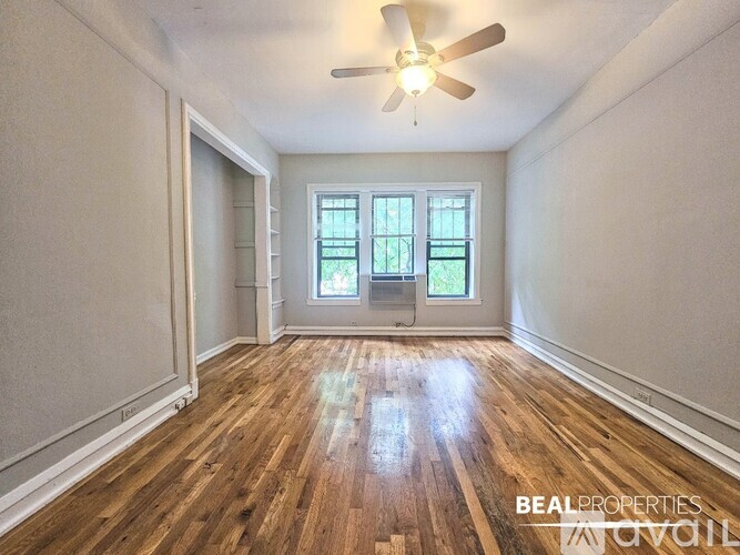 A room with wooden floors and a ceiling fan.