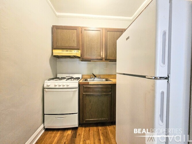 A spacious room with wooden floors and a ceiling fan.
