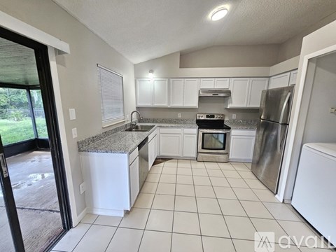 A kitchen with white cabinets and a granite countertop.