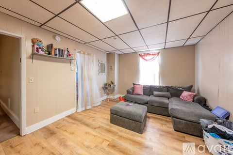 A living room with a grey couch and a wooden floor.