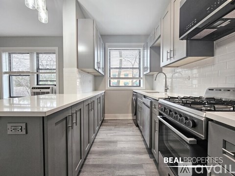 A modern kitchen with a stove top oven and a microwave above it.