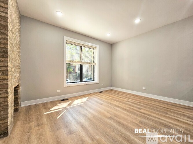 A spacious room with wooden flooring and white walls.