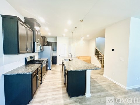 A kitchen with black cabinets and a granite countertop.