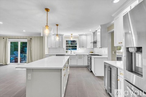 A modern kitchen with white cabinets and a large island.