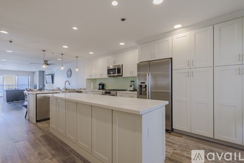 A kitchen with white cabinets and a large island.