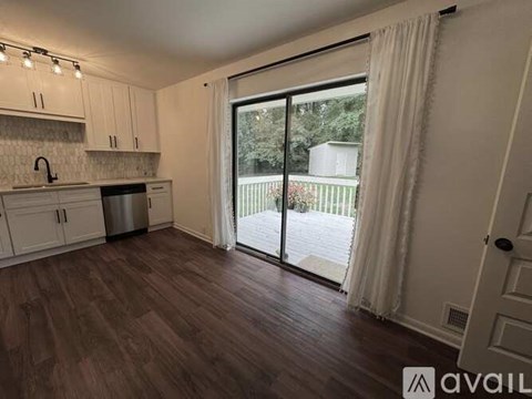 A kitchen with white cabinets and a wooden floor.