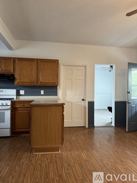 A kitchen with wooden cabinets and a white oven.