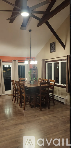 A dining room with a wooden table and chairs.