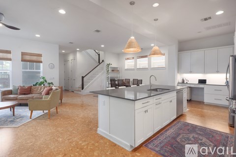 A kitchen with white cabinets and a wooden floor.