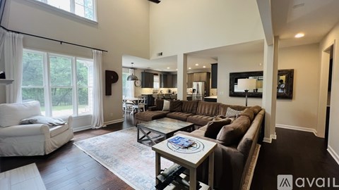 A living room with a brown leather couch and a white sofa.