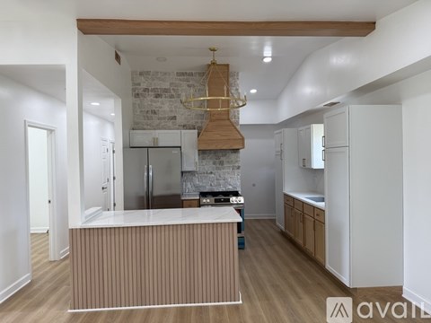 A kitchen with a white brick wall and wooden beams.