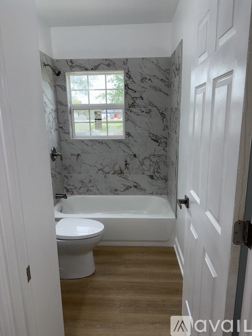 A bathroom with a marble wallpaper and a white toilet.