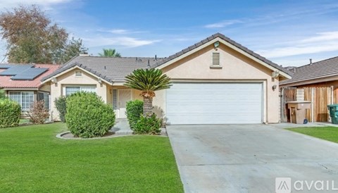 A house with a garage and a driveway in front of it.