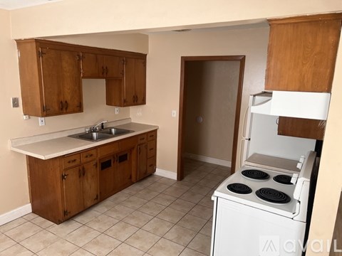 A kitchen with wooden cabinets and a white stove.