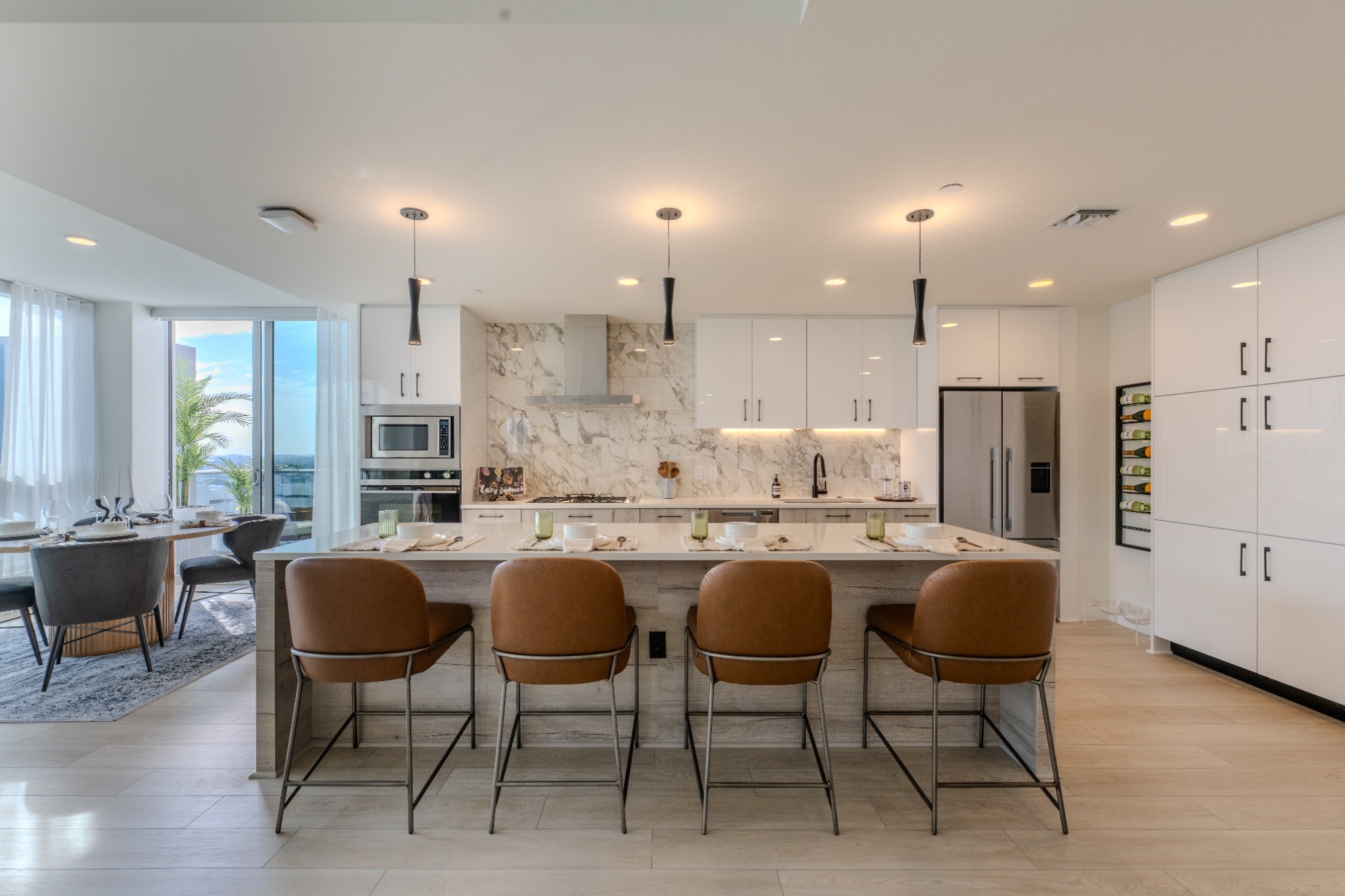 A modern kitchen with a marble backsplash and a dining table with four chairs.