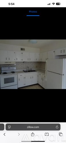 A kitchen with white cabinets and appliances.