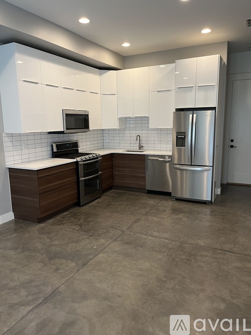 A modern kitchen with white cabinets and stainless steel appliances.