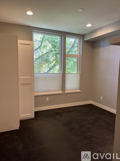 A room with a large window and a closed door.