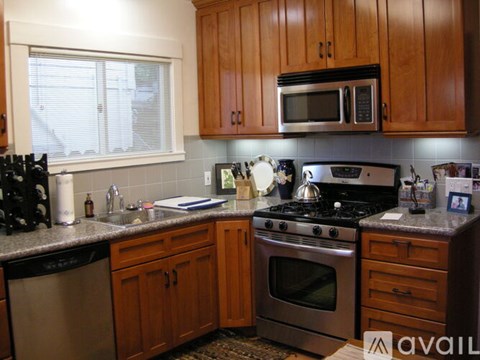 A kitchen with wooden cabinets and a stainless steel oven.
