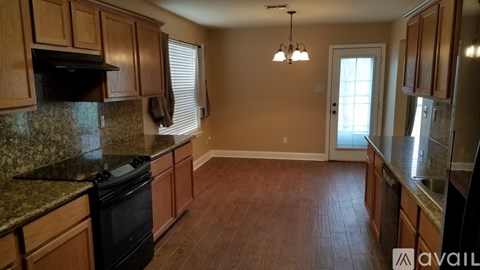 A kitchen with wooden cabinets and a granite countertop.