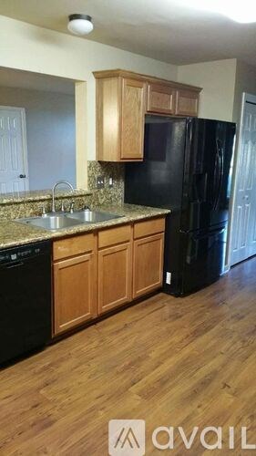A kitchen with wooden cabinets and black appliances.