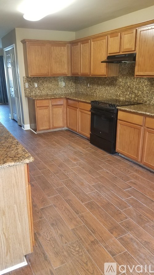A kitchen with wooden cabinets and a black oven.