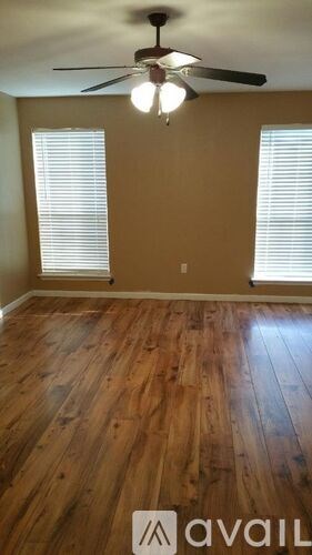 A room with wooden flooring and a ceiling fan.