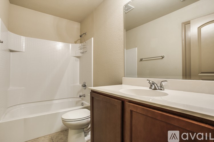 A bathroom with a white toilet, sink, and bathtub.