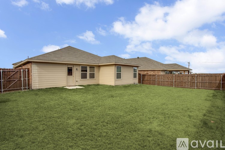 A house with a brown roof and a fence in front of it.