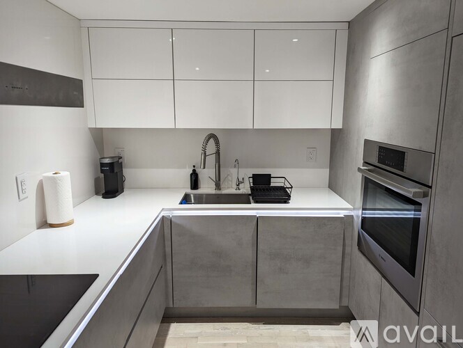 A modern kitchen with white cabinets and stainless steel appliances.