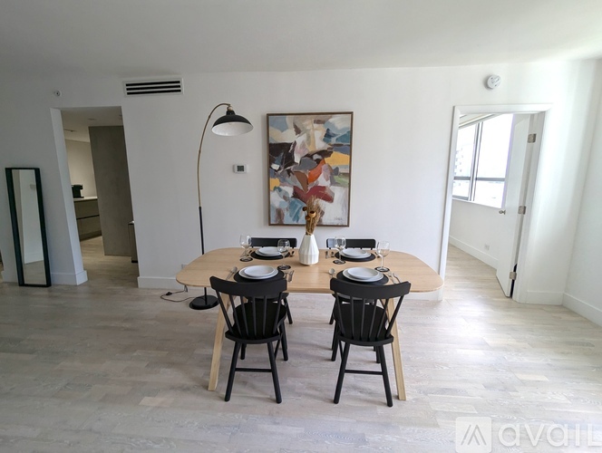 A dining room with a wooden table and chairs.