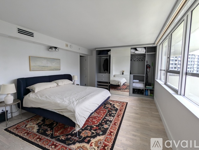 A bedroom with a large bed and a rug on the floor.