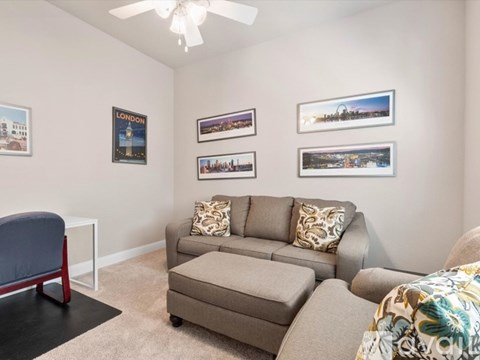 A living room with a grey couch and a blue chair.