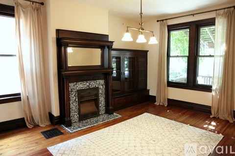A living room with a fireplace and a rug in front of it.
