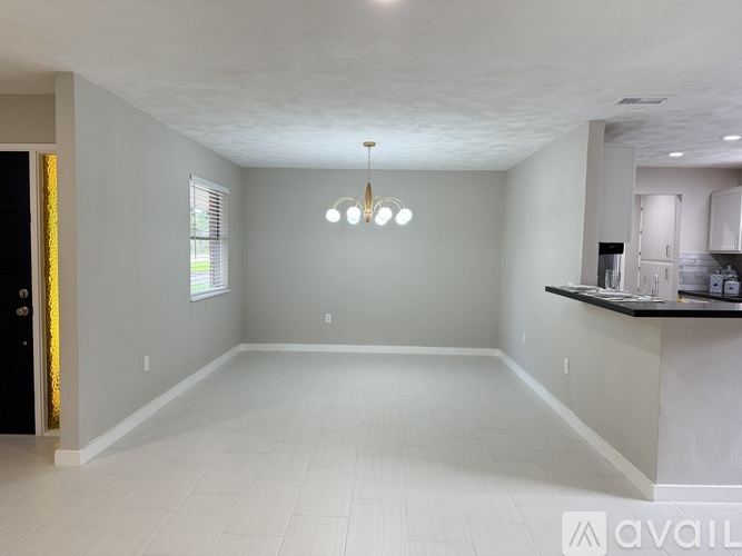 A spacious room with a bar area and a door on the left.