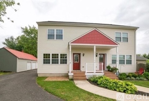 A house with a red roof and a white porch.
