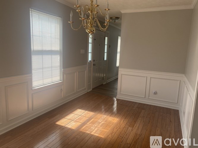 A room with wooden floors and a chandelier.