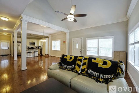 A living room with a couch and a ceiling fan.