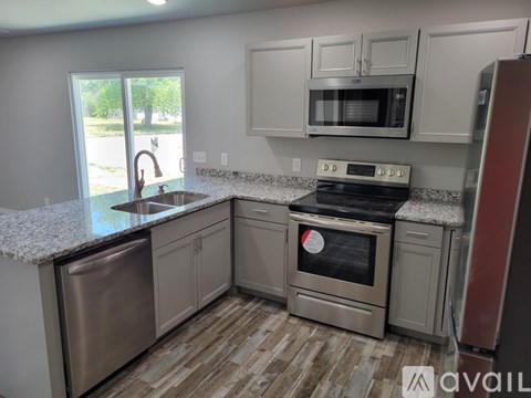 A kitchen with a stove top oven and microwave above it.