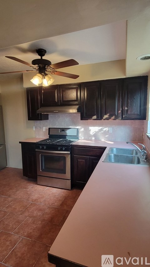 A kitchen with a fan and a stove top oven.