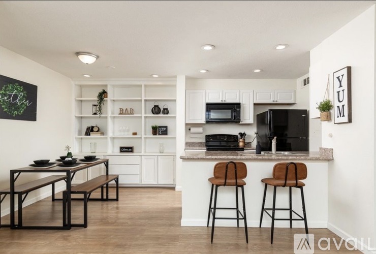 A modern kitchen with white cabinets and a bar area.