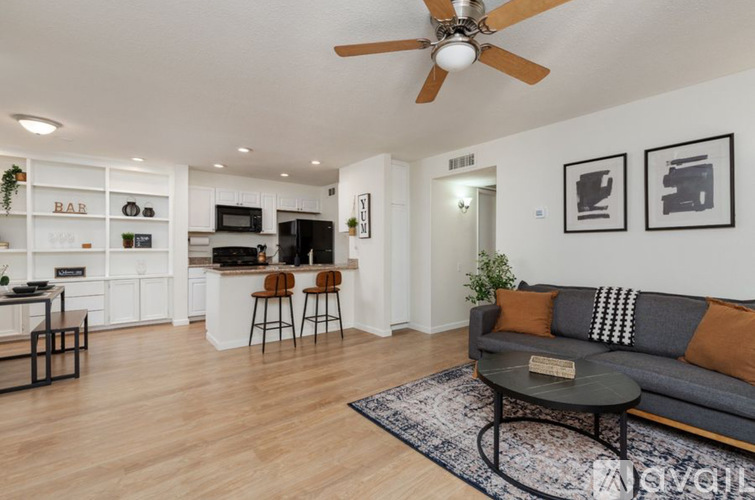 A living room with a grey couch and a ceiling fan.