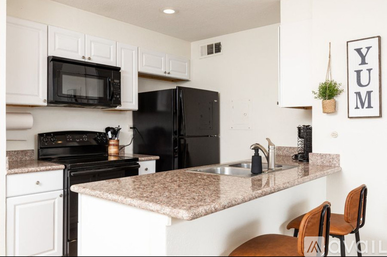 A kitchen with black appliances and white cabinets.