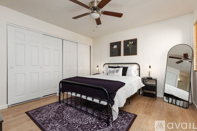 A bedroom with a bed, dresser, and mirror.