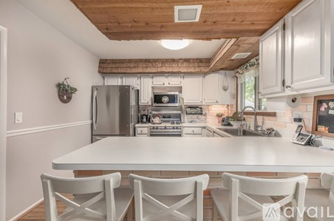 A kitchen with a white table and chairs.
